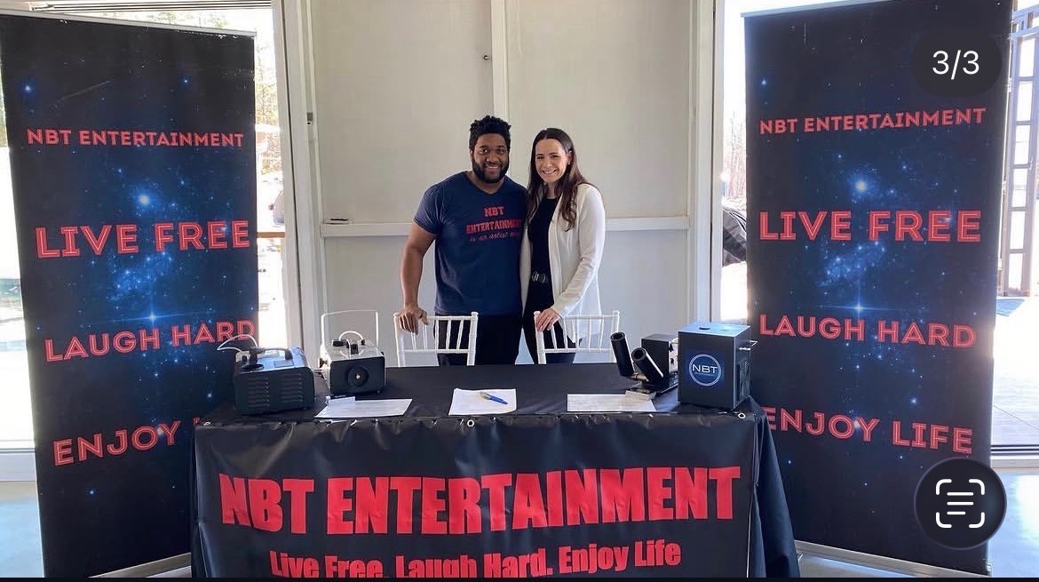 NBT Entertainment branded booth setup with team members at an event