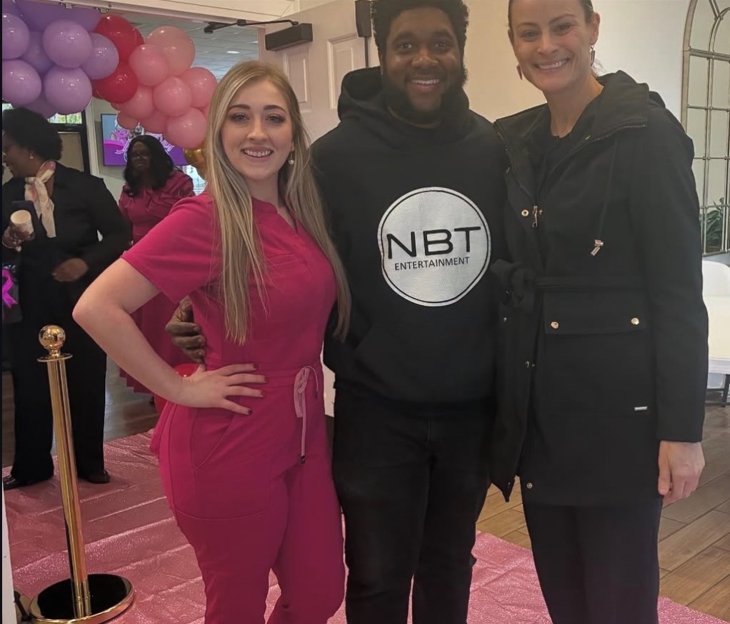 NBT Entertainment host posing with two guests at a pink themed event